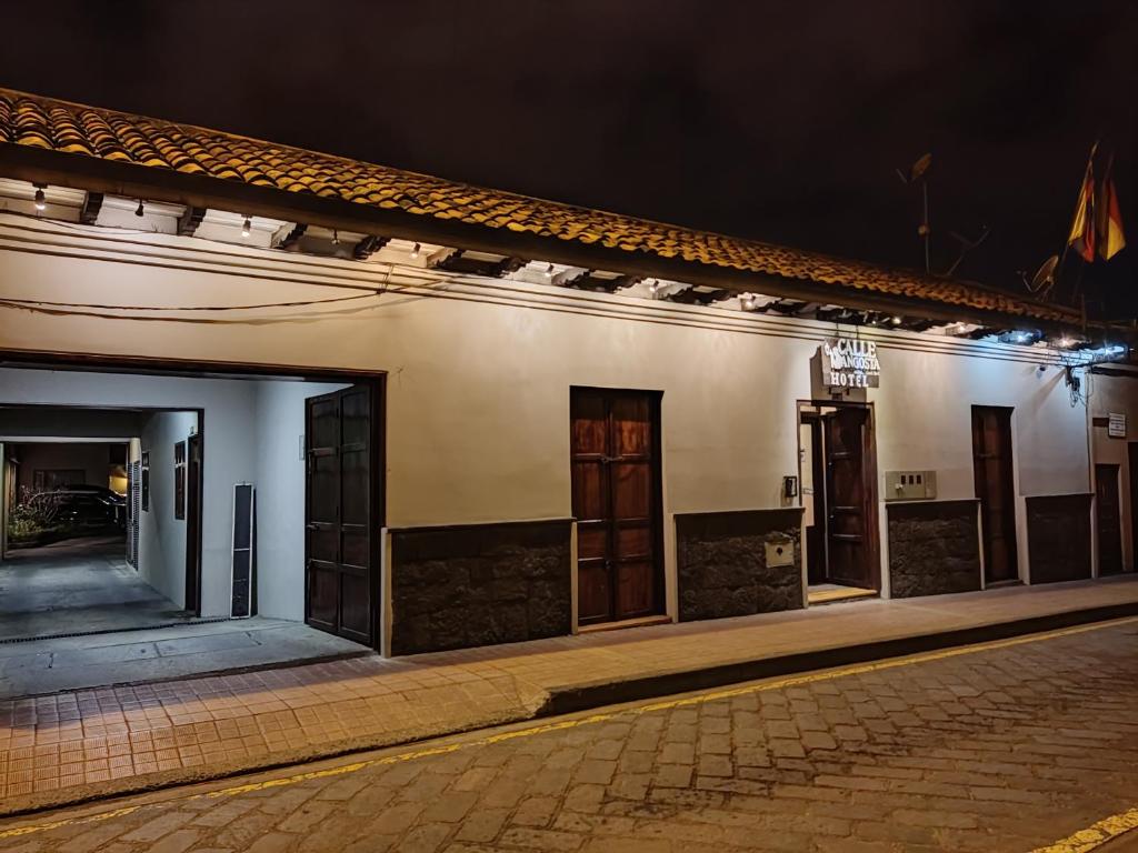 a row of doors on a building at night at Hotel Calle Angosta in Cuenca