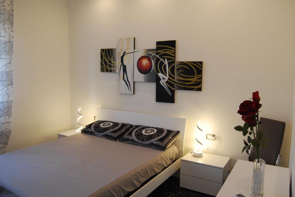 um quarto com uma cama e pinturas na parede em ORIZZONTE SUL MARE em Savona
