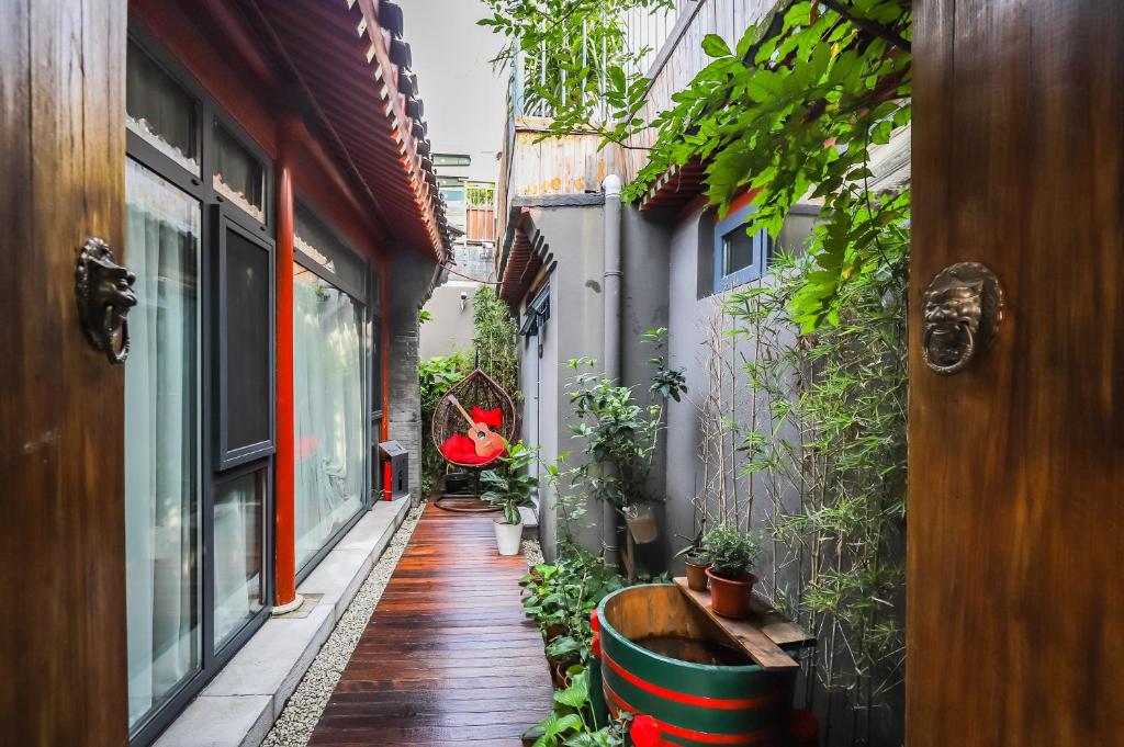 a narrow alley with plants and a wooden floor at Templeside Beijing in Beijing
