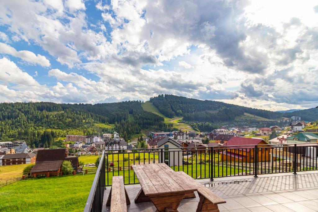 a picnic table on a balcony with a view of a city at Comfort House in Bukovel