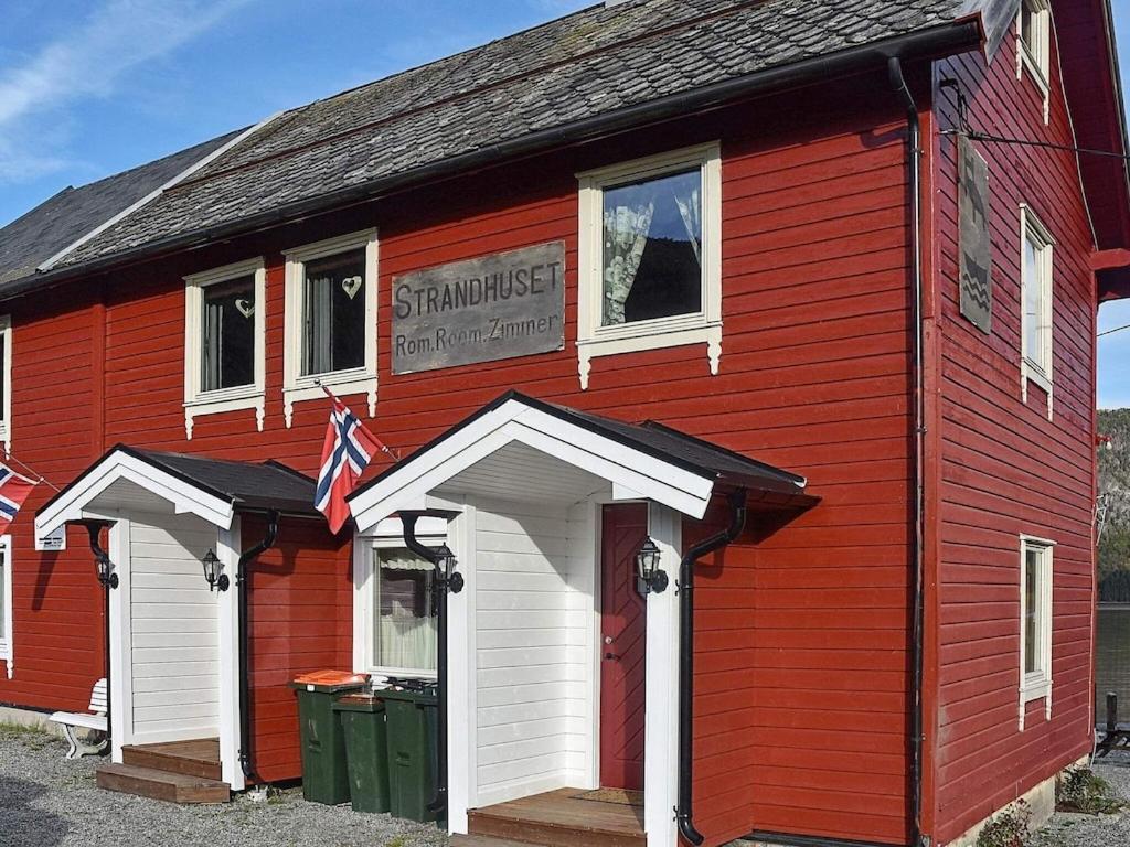 a red building with a sign on the side of it at Three-Bedroom Holiday home in Måndalen in Sæbø