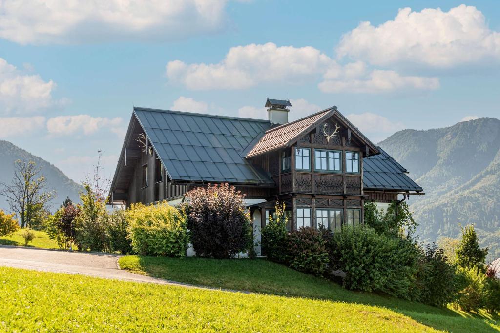 a house on a hill with mountains in the background at Bergvilla Oberon in Bad Aussee