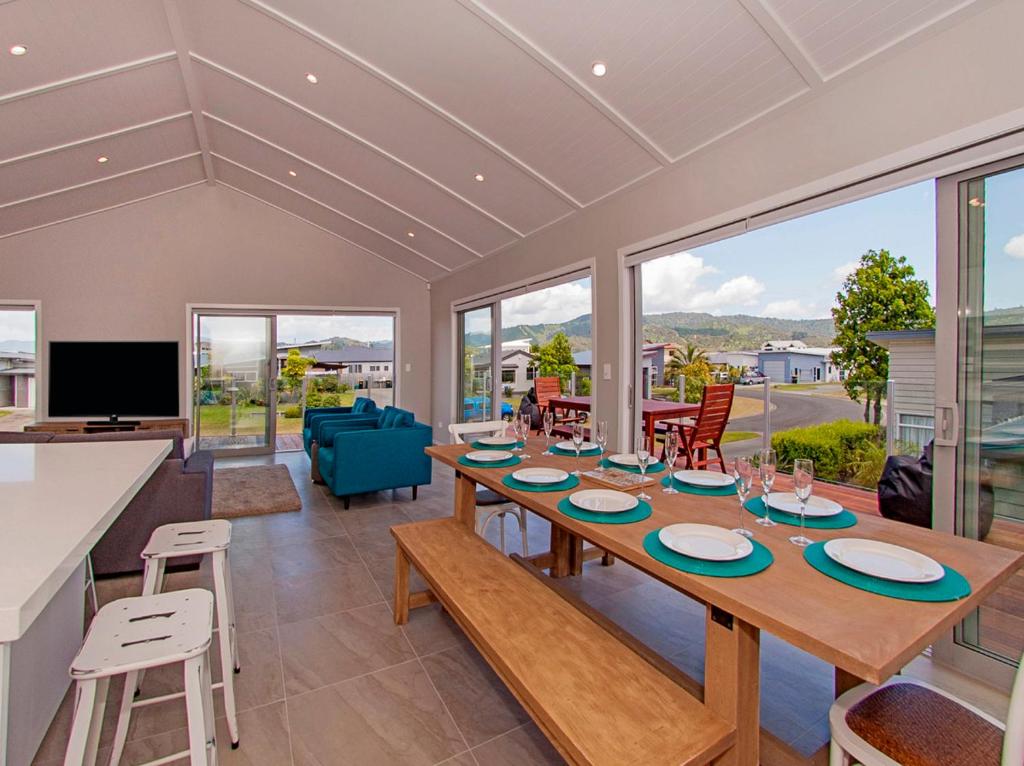 a dining room with a table and some chairs at Tattletails Rest - Whitianga Holiday House in Whitianga