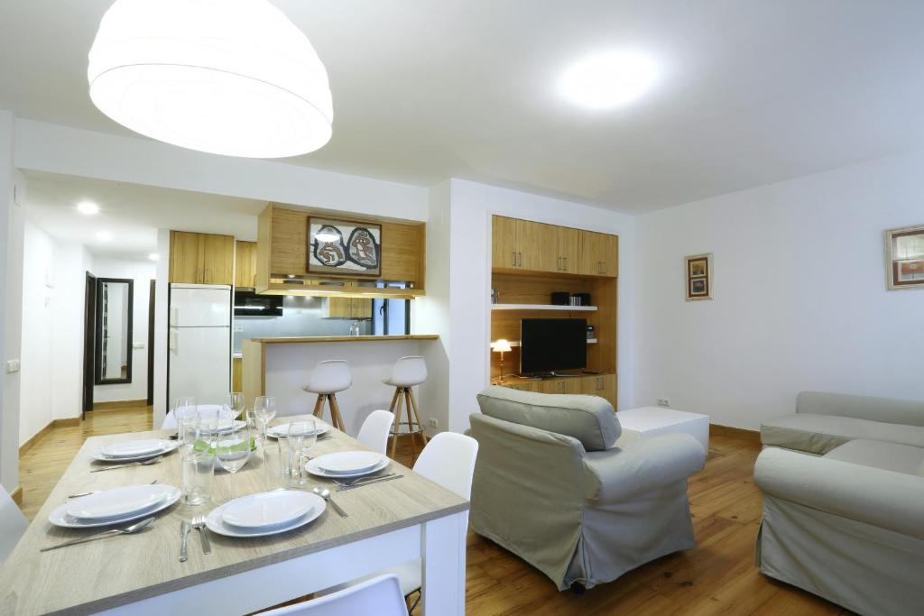 eine Küche und ein Wohnzimmer mit einem Tisch und Stühlen in der Unterkunft Andagoia by Smiling Rentals in Hondarribia
