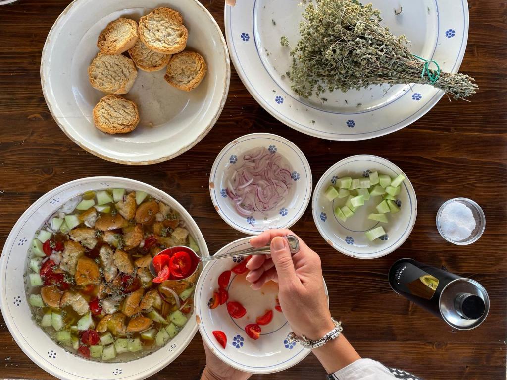 a woman is preparing food on a table with plates of food at Masseria Borgo Santuri in Ostuni