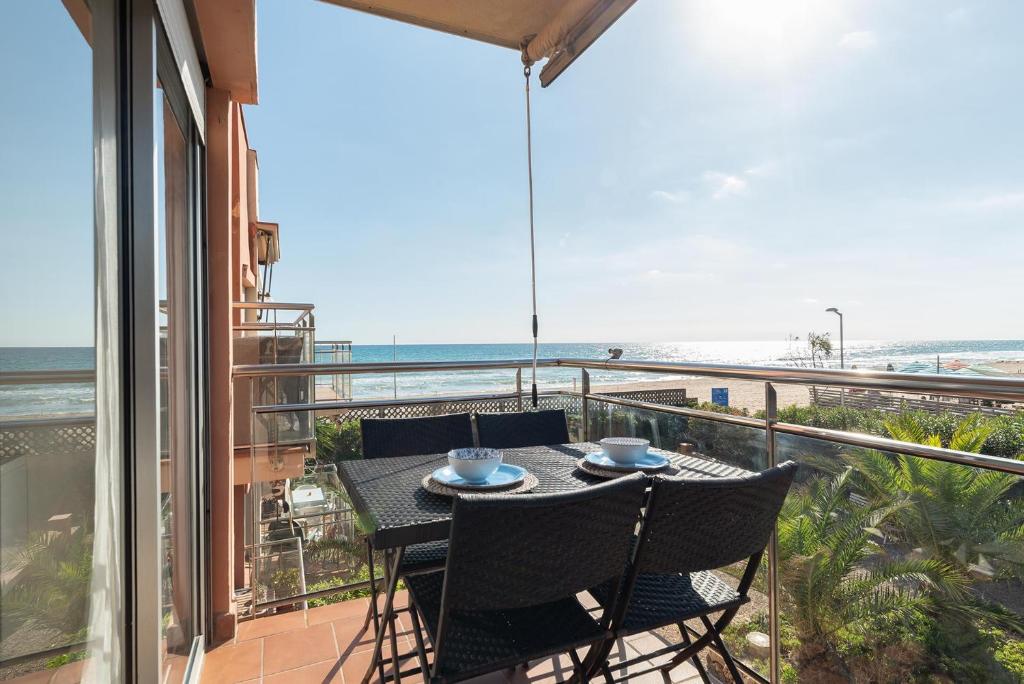 a table and chairs on a balcony with a view of the ocean at Ocean view apartment renovated in Gavà