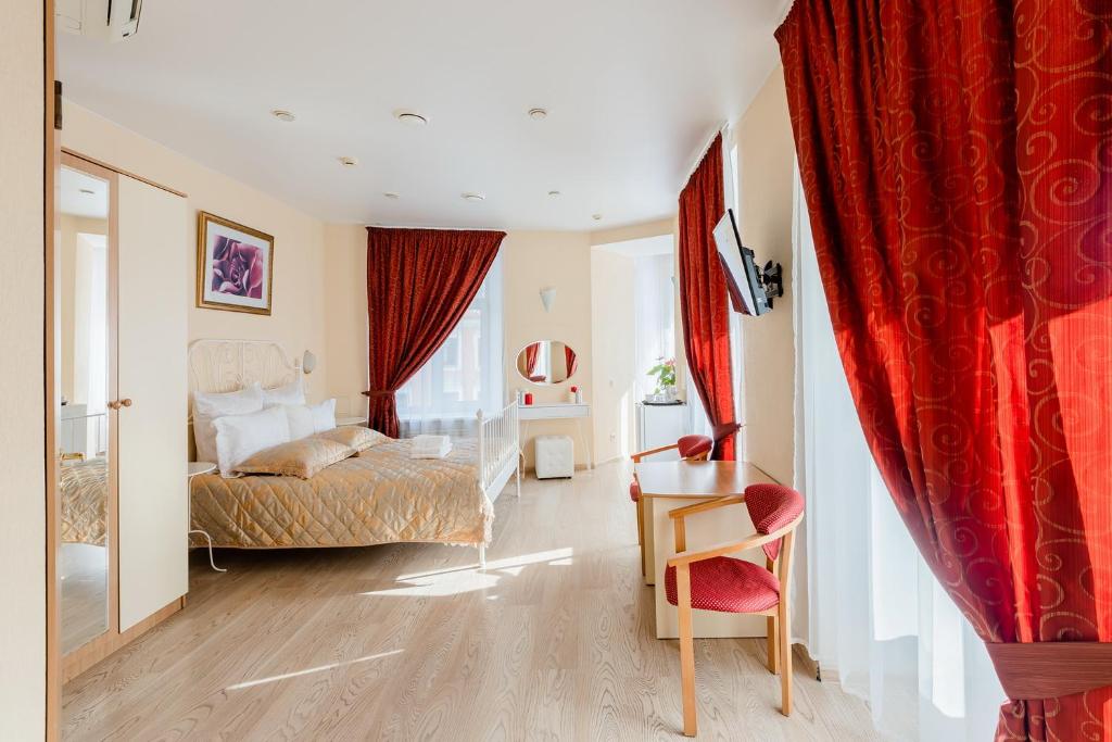 サンクトペテルブルクにあるOctaviana Hotelのベッドルーム1室(ベッド1台、テーブル、椅子付)