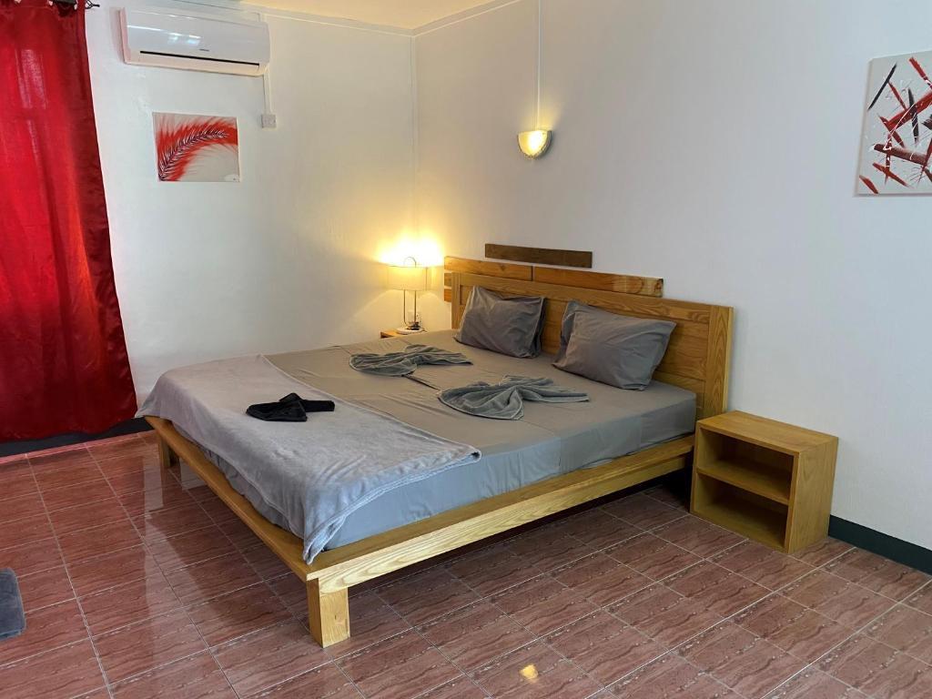 - une chambre avec un lit dans un dortoir doté d'une lampe dans l'établissement Le Pôle, à Grand Baie