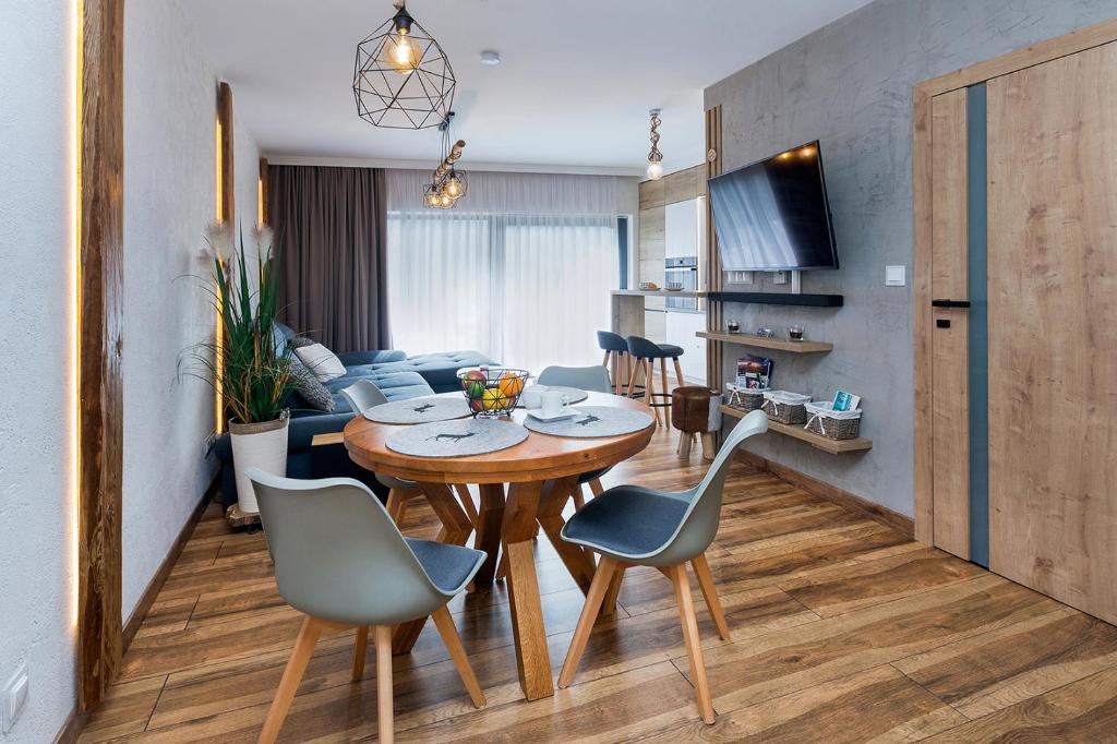a dining room and living room with a table and chairs at SPA Apartament Jenny Ski&Fun&Bike Szkolna ładowarka E-bike piękny widok na Skrzyczne i skocznię "Skalite" in Szczyrk