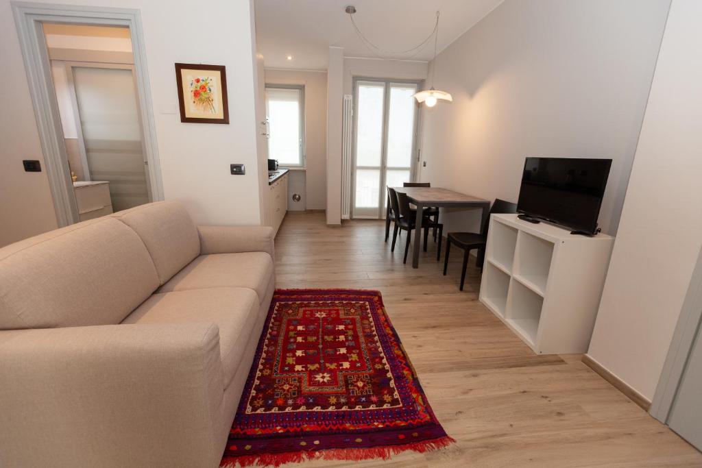 a living room with a couch and a dining room at Rossini15 - garage privato in Alba