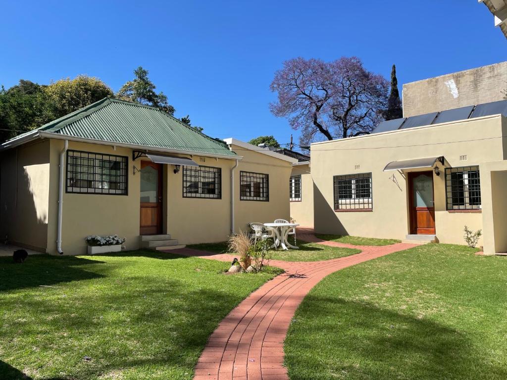 una casa con un passaggio pedonale in mattoni di fronte a un cortile di BaobabSuites a Johannesburg