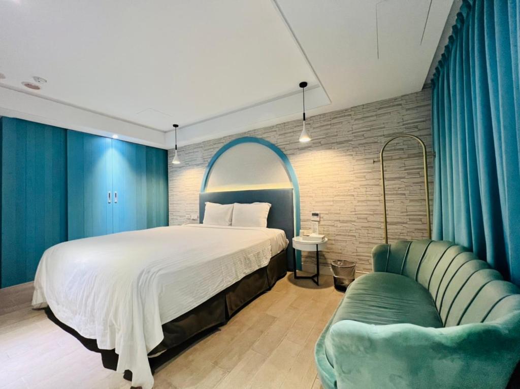 um quarto com uma cama grande e um sofá em Formosa Motel & Inn em Changhua