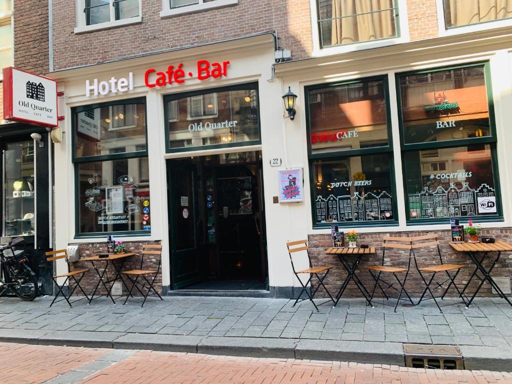 a hotel cafe bar with tables in front of a building at Hotel Old Quarter in Amsterdam