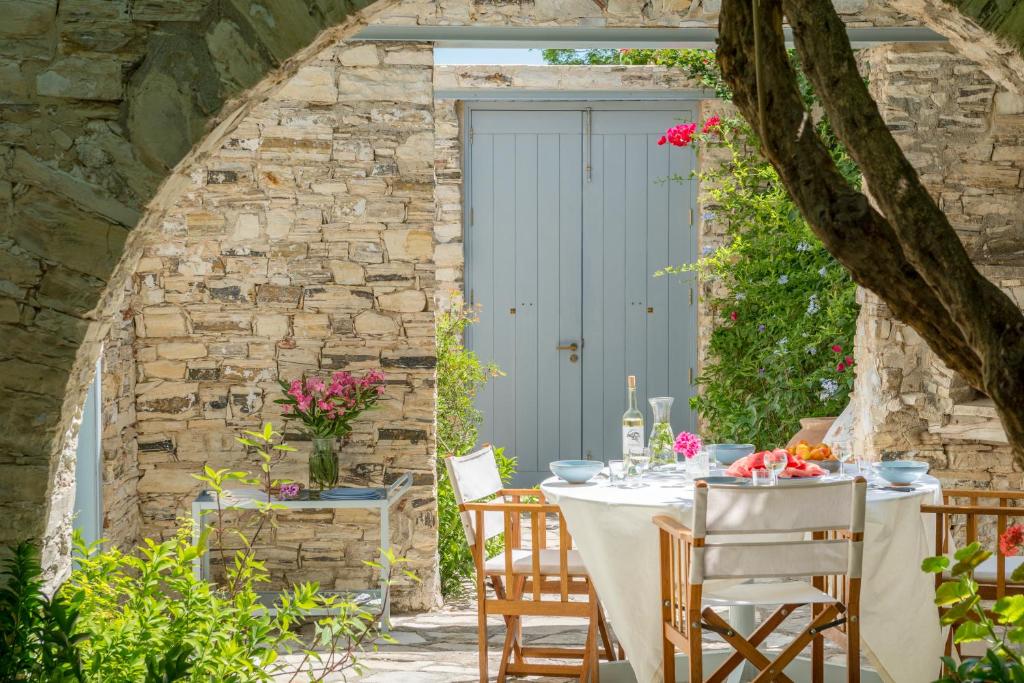 una mesa al aire libre con sillas y una puerta azul en Ample Places, en Pano Lefkara