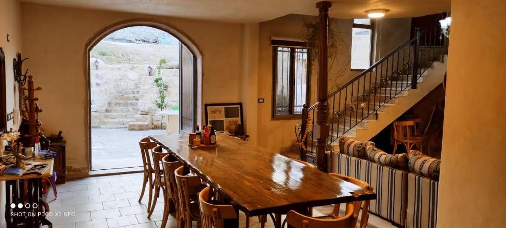 una grande sala da pranzo con tavolo e sedie in legno di Nonna Aisha B&B a Wadi Musa