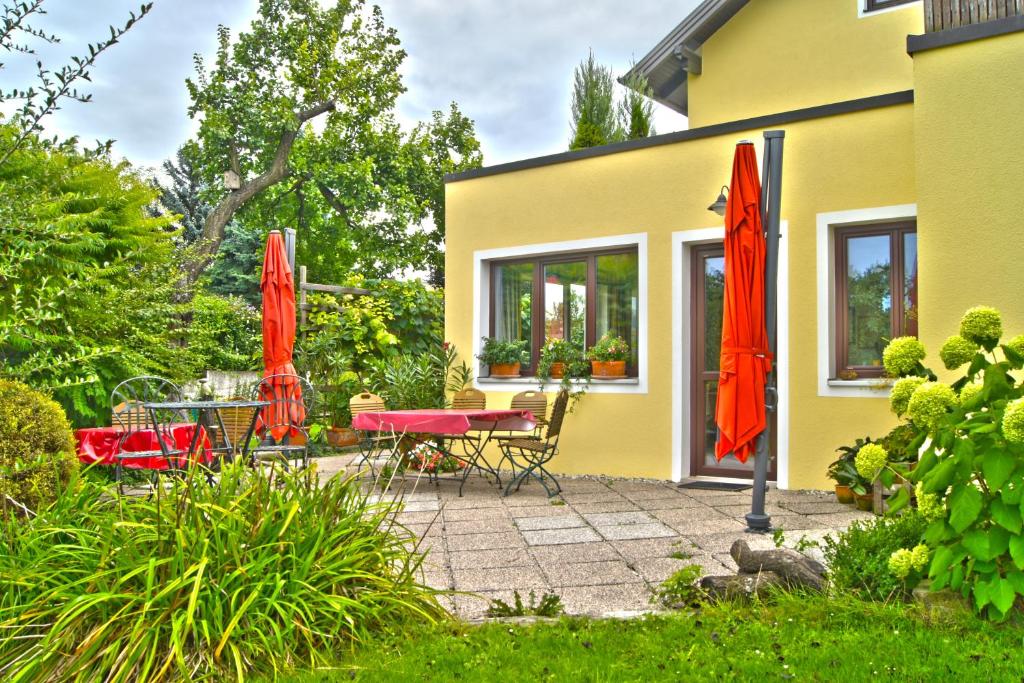 a patio with red umbrellas and a table and chairs at Gästezimmer Ilse Brauneis in Mautern