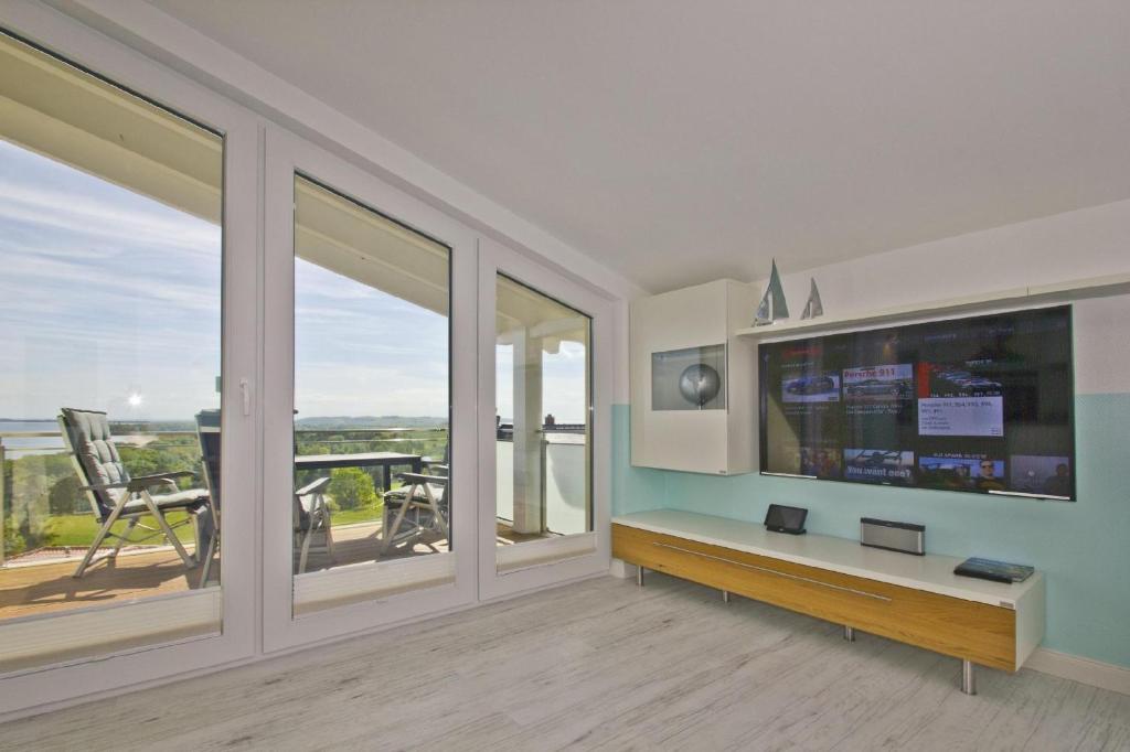 TV a/nebo společenská místnost v ubytování Meeresblick-Residenzen-FeWo-67-deluxe-Balkon-Meerblick-Sauna-u-Schwimmbadnutzung