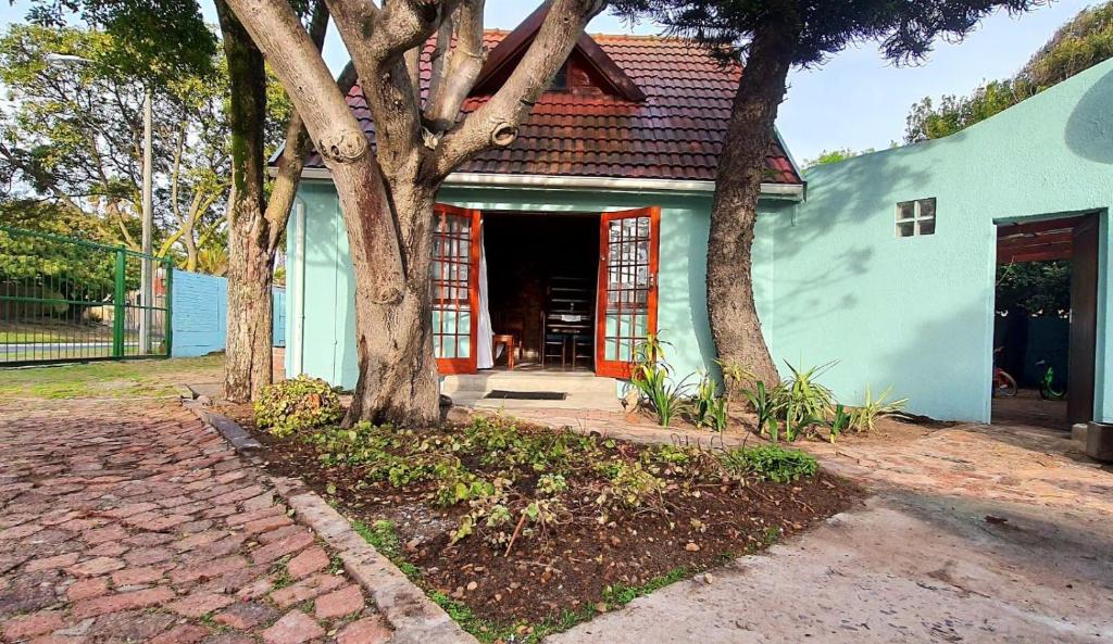 une maison avec un arbre en face dans l'établissement Cozy Cottage +/- 500m from the beach, au Cap