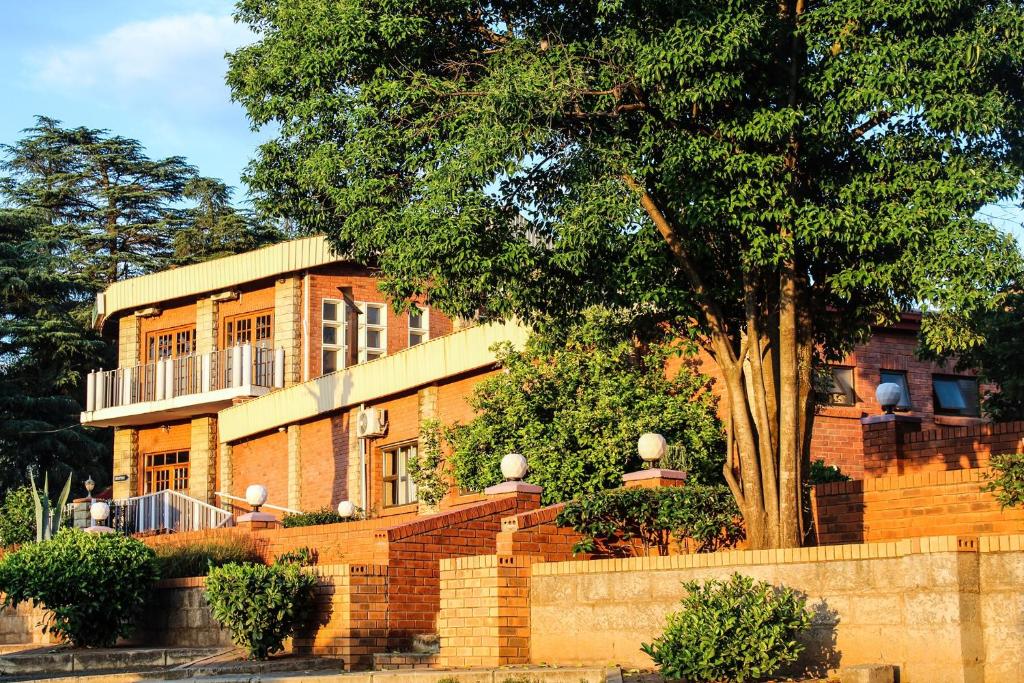 uma casa de tijolos com uma árvore em frente em Mountain View Hotel - Lesotho em Leribe