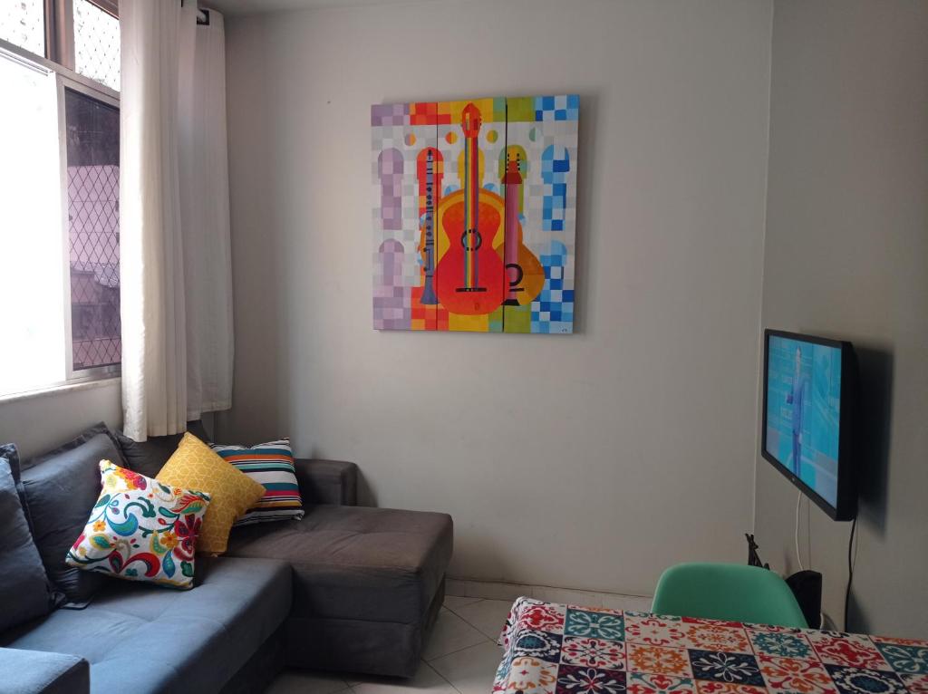 una sala de estar con una pintura de violín en la pared en Lapa fácil mobilidade no Rio ap 2 quartos, en Río de Janeiro