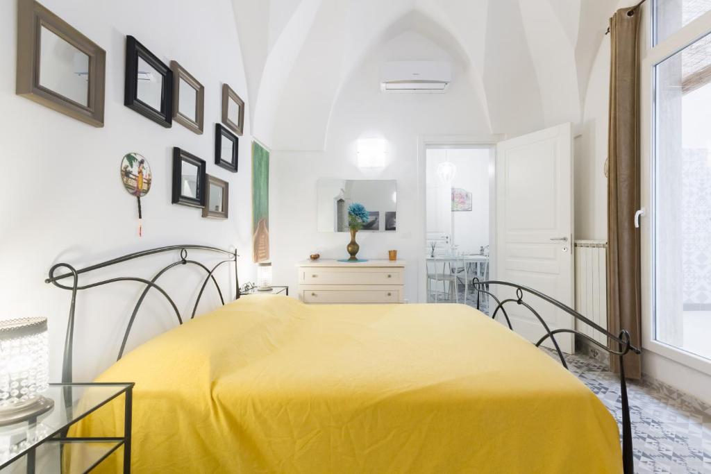 a bedroom with a yellow bed and a table at Maison Rudy - by Annet in Lecce