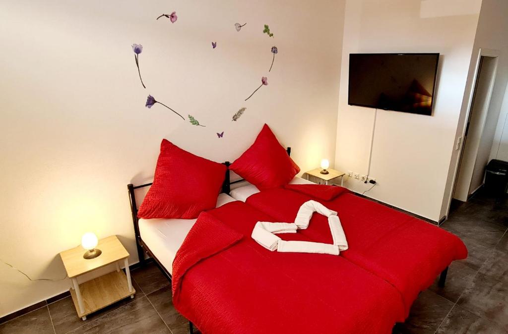 a bedroom with a red bed with red pillows at Pension Fürstenzell in Fürstenzell