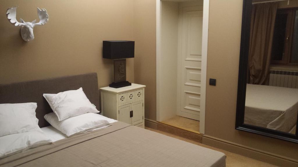 a bedroom with a bed and a lamp and a mirror at Villa Victoria-Loven Park Sofia in Sofia