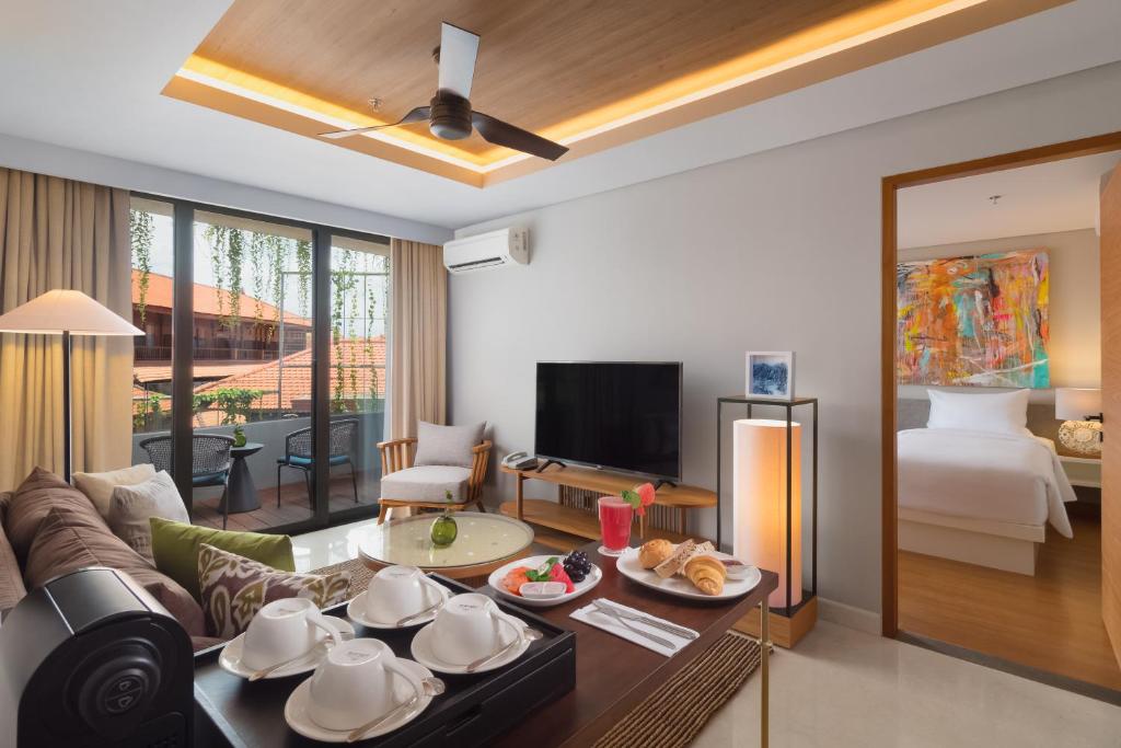 a living room with a couch and a bed at Beachwalk Residence in Kuta