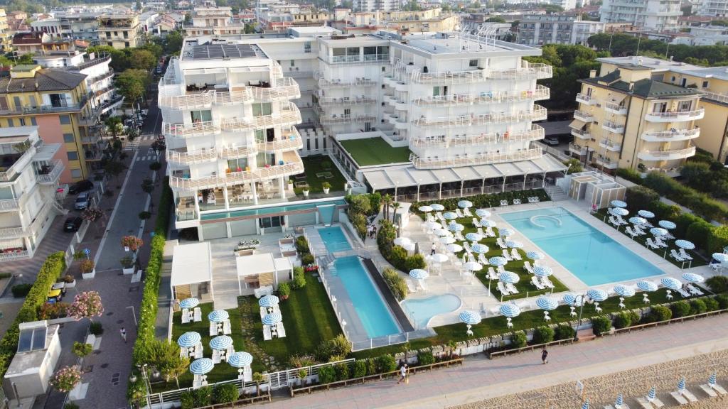 eine Luftansicht eines Resorts mit Pool und Gebäuden in der Unterkunft Hotel Le Soleil in Lido di Jesolo