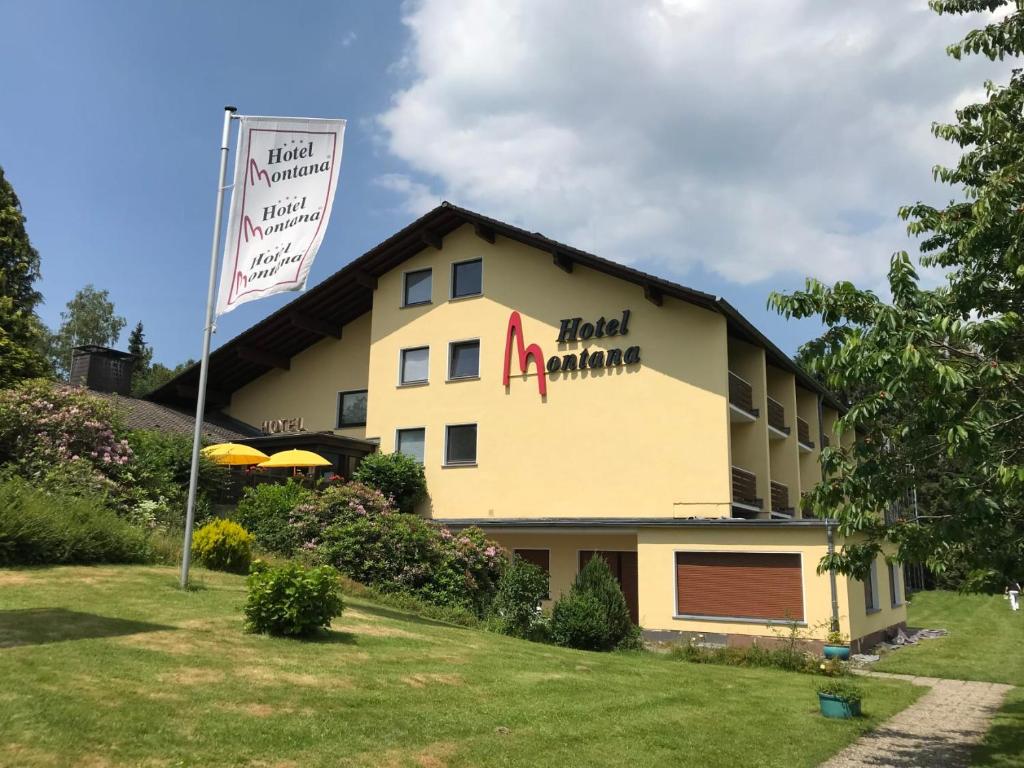 a hotel with a sign on the side of a building at Montana Landhotel Gummersbach-Nord in Marienheide