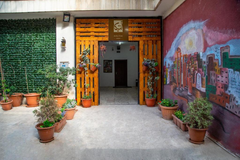 un corridoio con piante in vaso e un dipinto sul muro di Antika Amman Hotel ad Amman