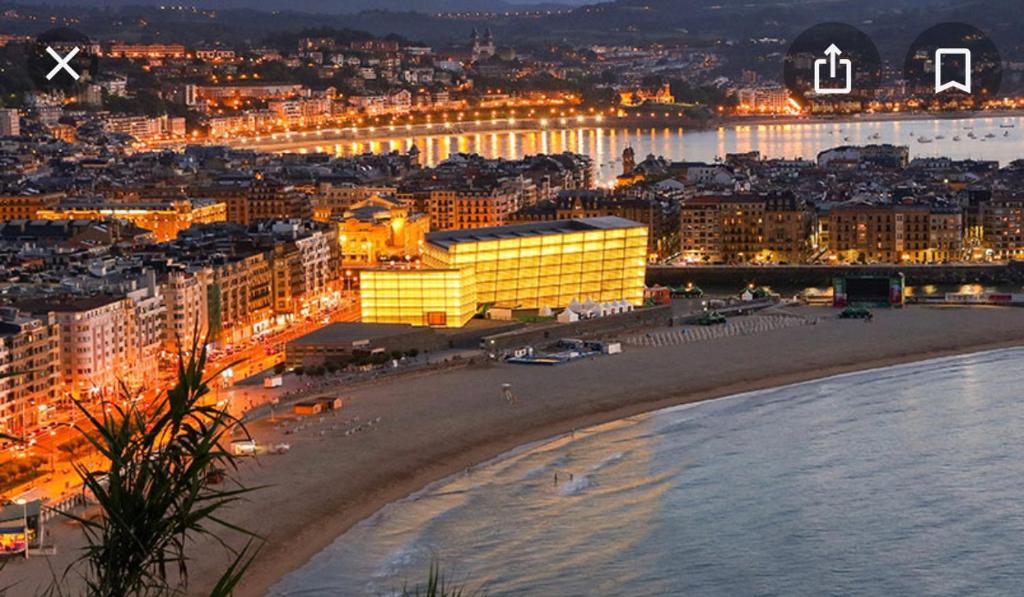 Blick auf den Strand und die Gebäude in der Nacht in der Unterkunft Magnifica swit room sama in San Sebastián