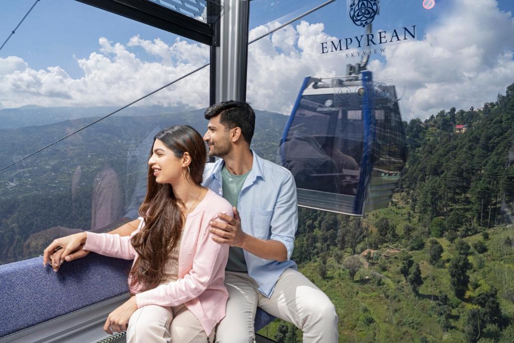 a man and a woman sitting on a gondola at Skyview by Empyrean in Patnitop