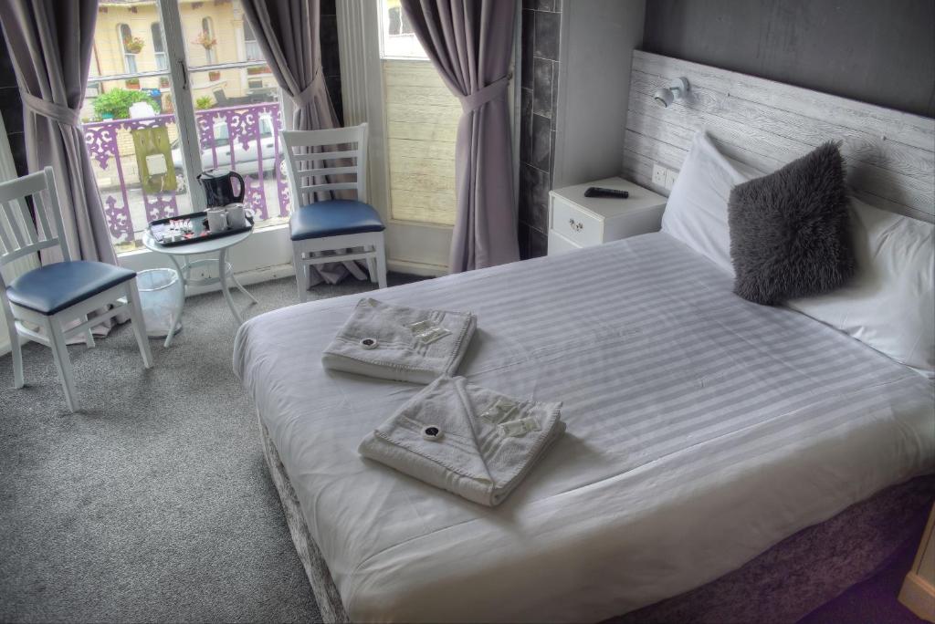 a bedroom with a white bed with two pillows on it at Villa Rose in Great Yarmouth