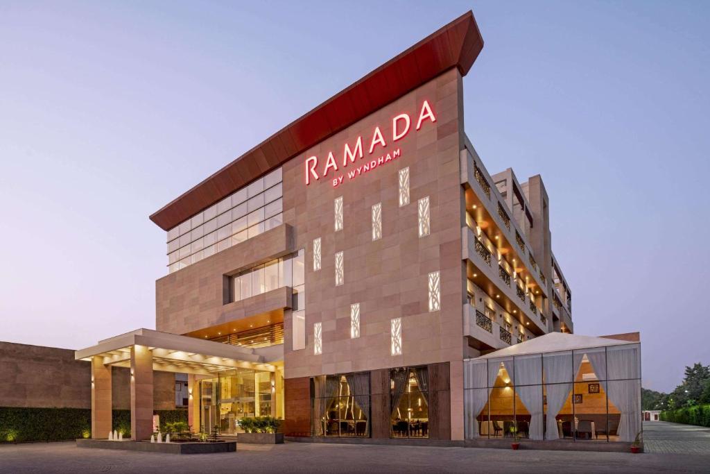 a building with aania sign on the front of it at Ramada by Wyndham Aligarh GT Road in Alīgarh