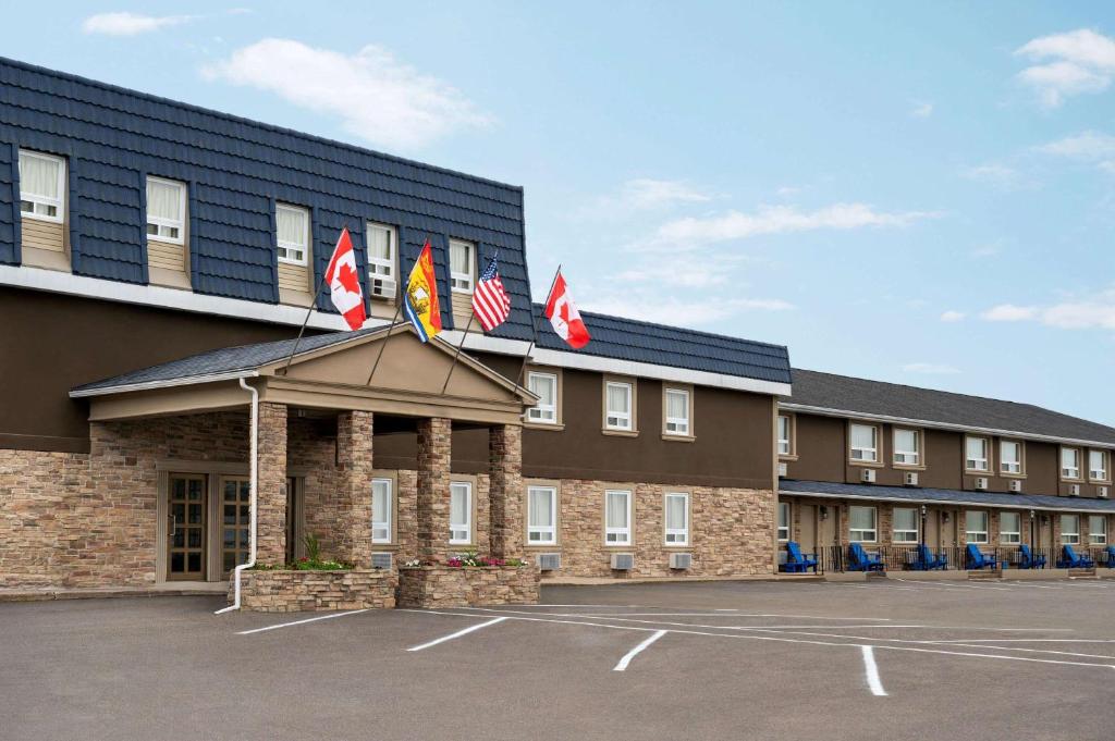 hotel z flagami na przedniej stronie budynku w obiekcie Days Inn by Wyndham Fredericton w mieście Fredericton