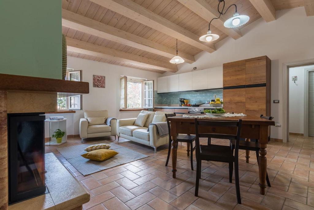 cocina y sala de estar con mesa y sofá en Villa Rosa, en Fossombrone