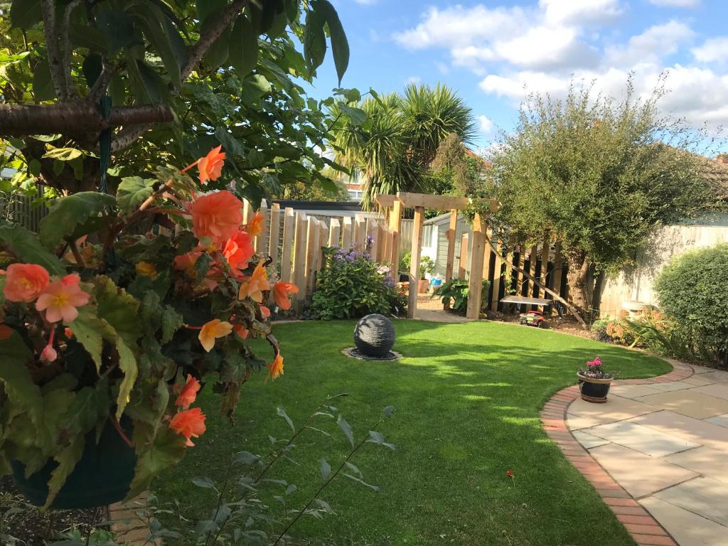 a garden with orange flowers and a fence at Bub Lane Cottage in Christchurch
