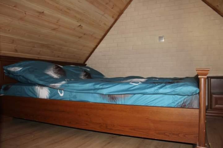 Eine Katze, die auf einem Bett im Dachgeschoss schläft. in der Unterkunft Domek letniskowy 6-osobowy całoroczny nad jeziorem Wilczyńskim in Świętne