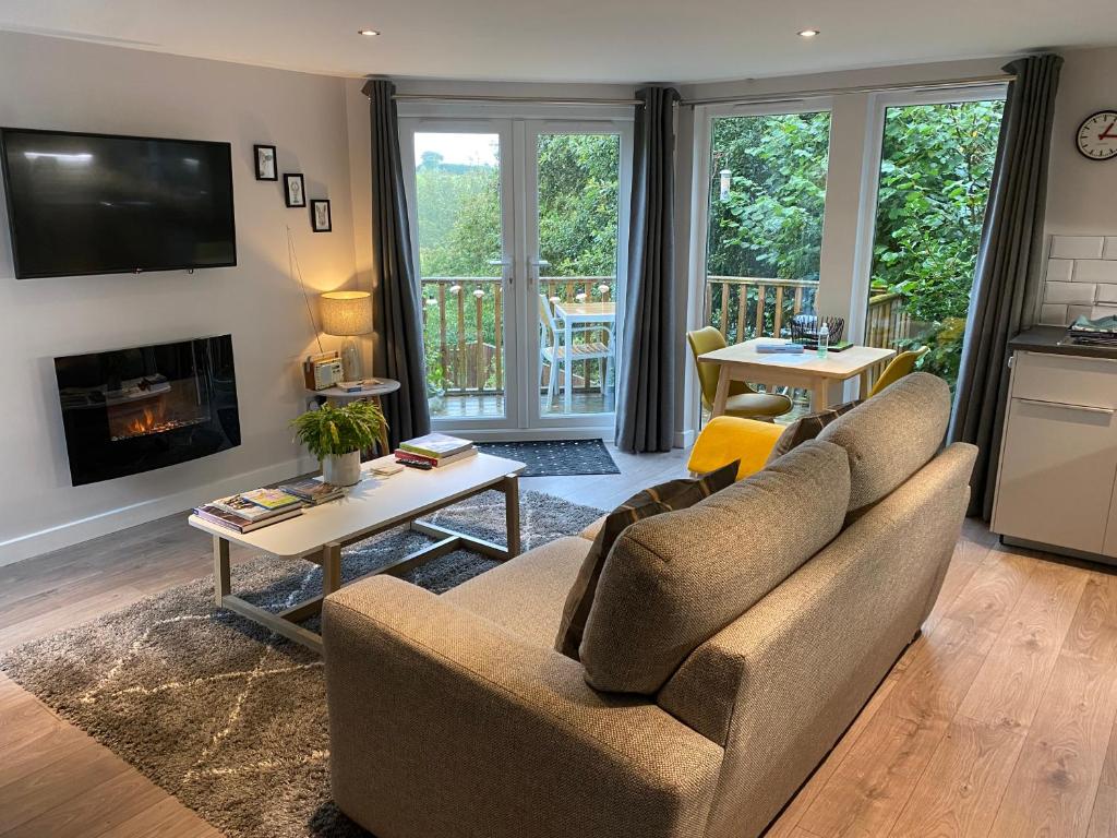 a living room with a couch and a fireplace at The Hutch Devon in Longdown