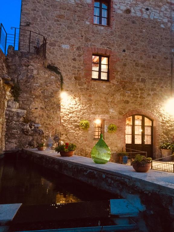a brick building with two green vases in front of it at Molino dei Preti in Asciano