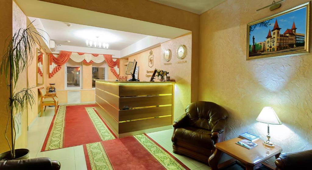 a living room with a chair and a dresser at Hotel Saratovskaya in Saratov