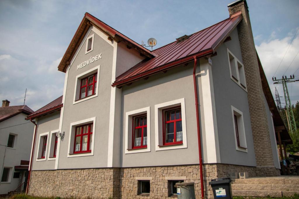 a house with red windows and a red roof at Penzion Medvídek Tanvald in Tanvald