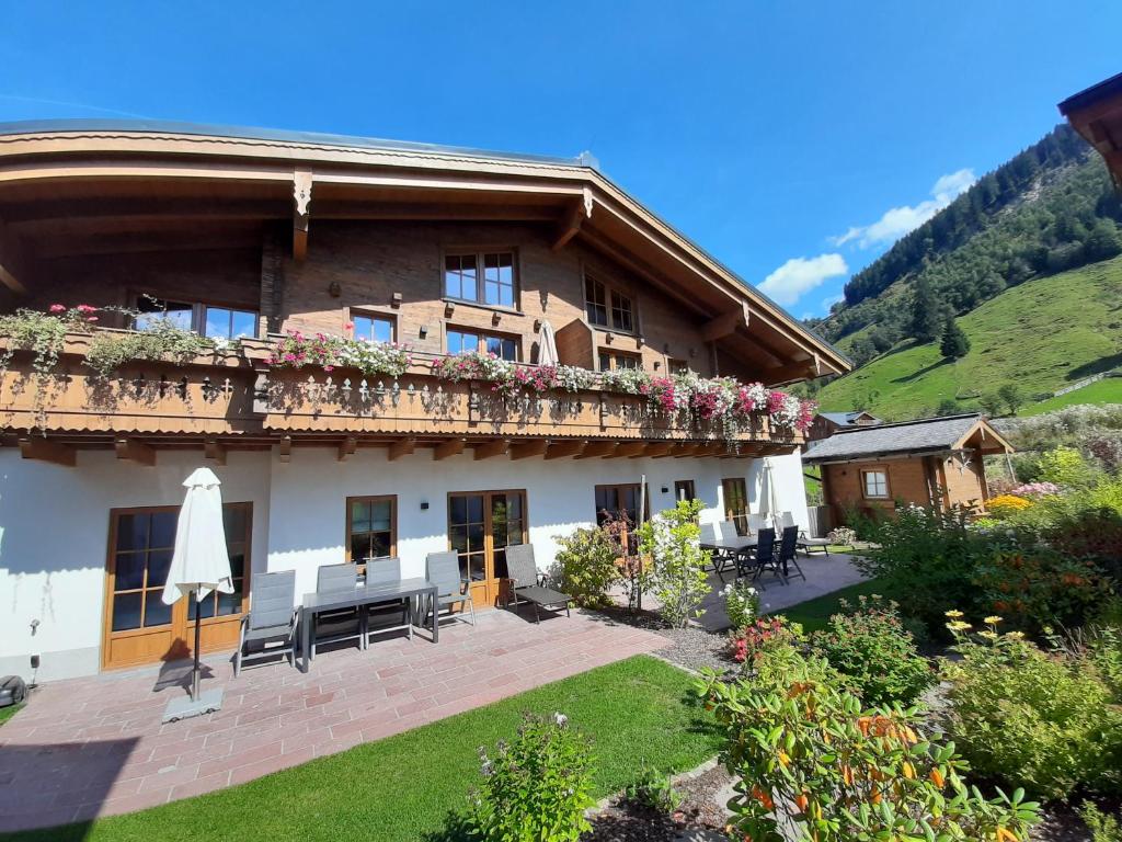 a building with a balcony with flowers on it at Hochalmbahnen Chalets Rauris 1-06 WE2 Maislaufeldweg 1g EG in Rauris