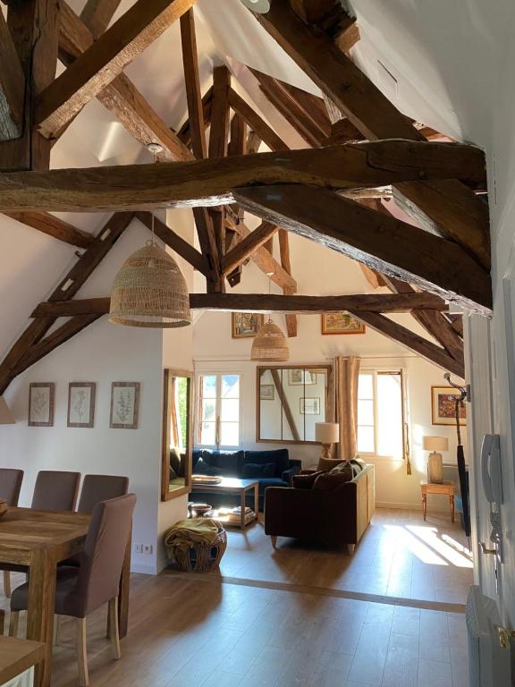 布爾日的住宿－Aux 3 Maillets，一间带木制天花板的客厅和一间带沙发的房间