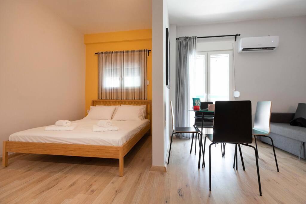 um quarto com uma cama, uma mesa e cadeiras em The brand new House meets the ideal location Apt2 em Atenas