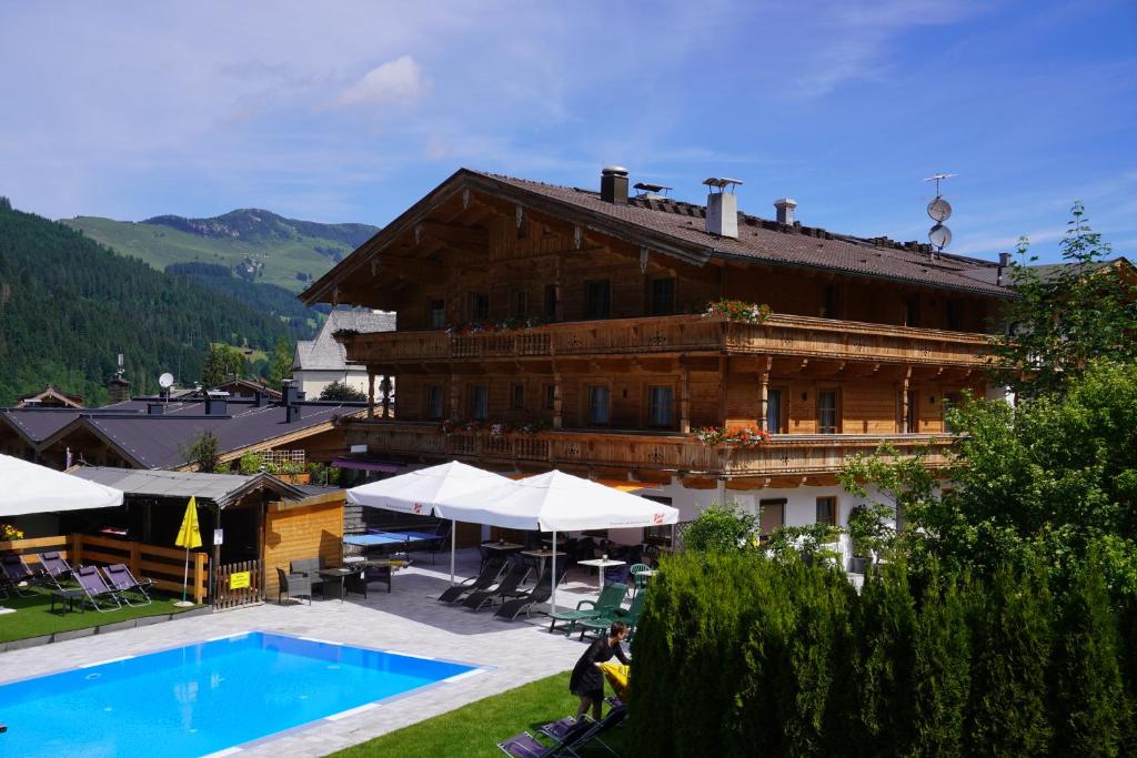 un gran edificio con una piscina frente a él en Hotel Aschauer Hof z'Fritzn, en Kirchberg in Tirol