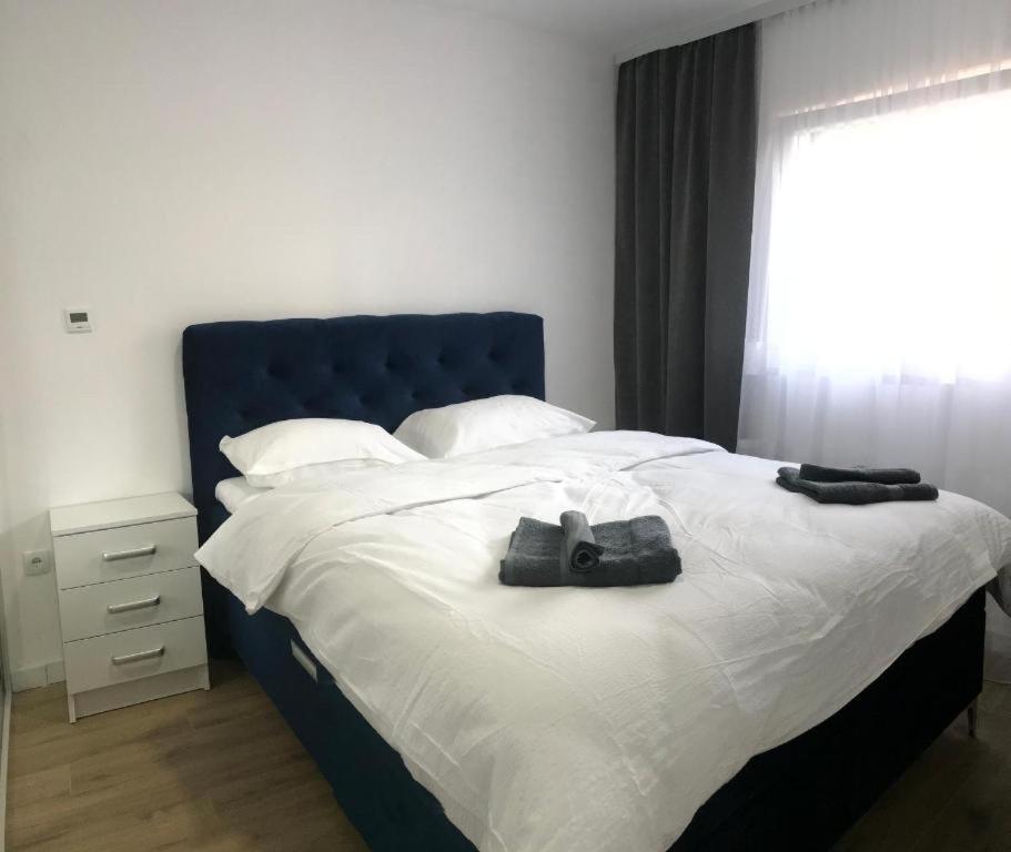 1 dormitorio con 1 cama con cabecero azul y ventana en Central Аpartment Foca - with garage en Foča