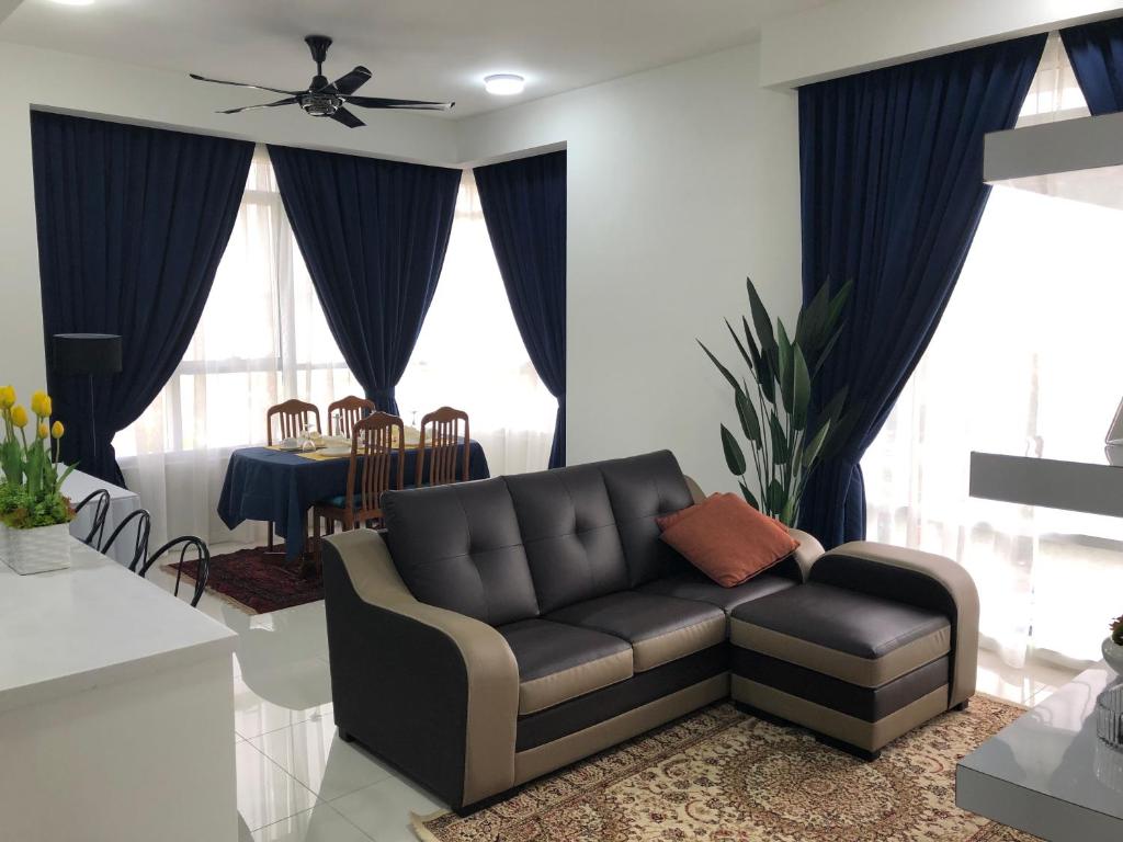 ein Wohnzimmer mit einem Sofa und einem Tisch in der Unterkunft JW Homestay The Ridge KL East in Kuala Lumpur