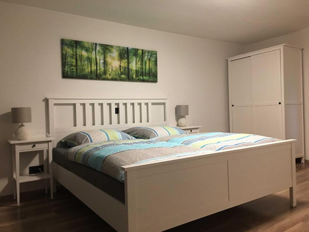 a bedroom with a white bed and a painting on the wall at Haus Allgäu Ruh in Görisried